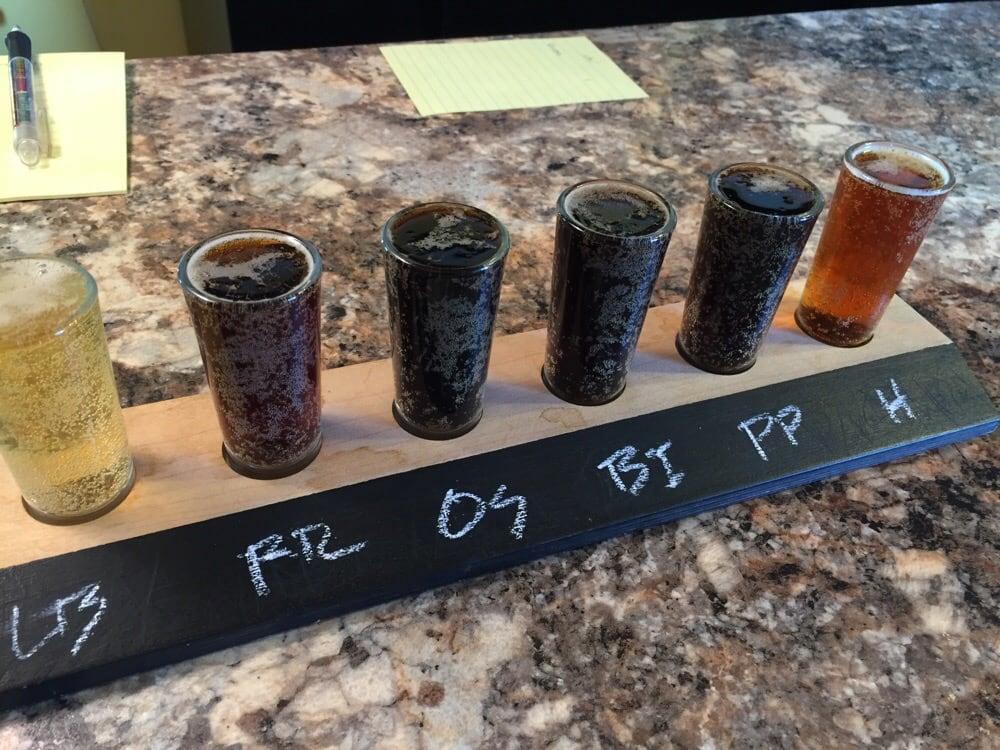 A flight of dark beers on the bar