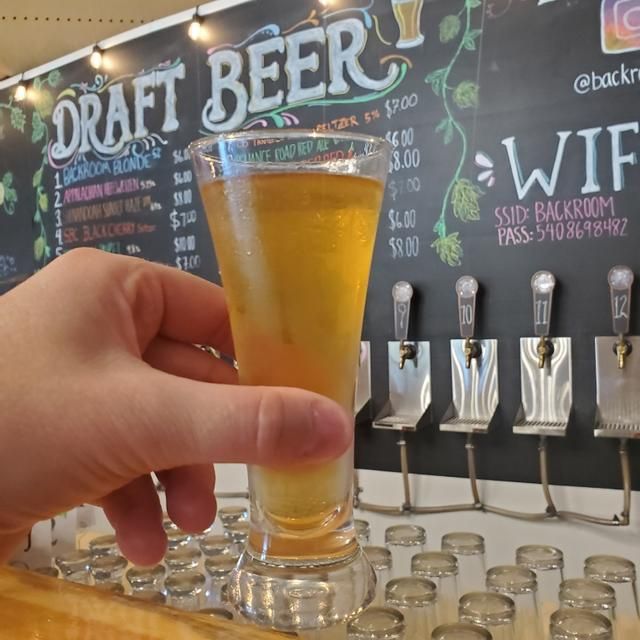 A fresh pour in front of the chalkboard tap list