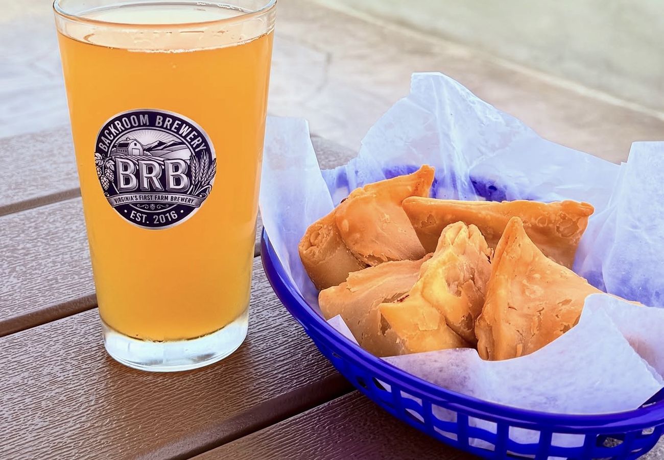 A hazy pint in a BRB glass beside a basket of samosas