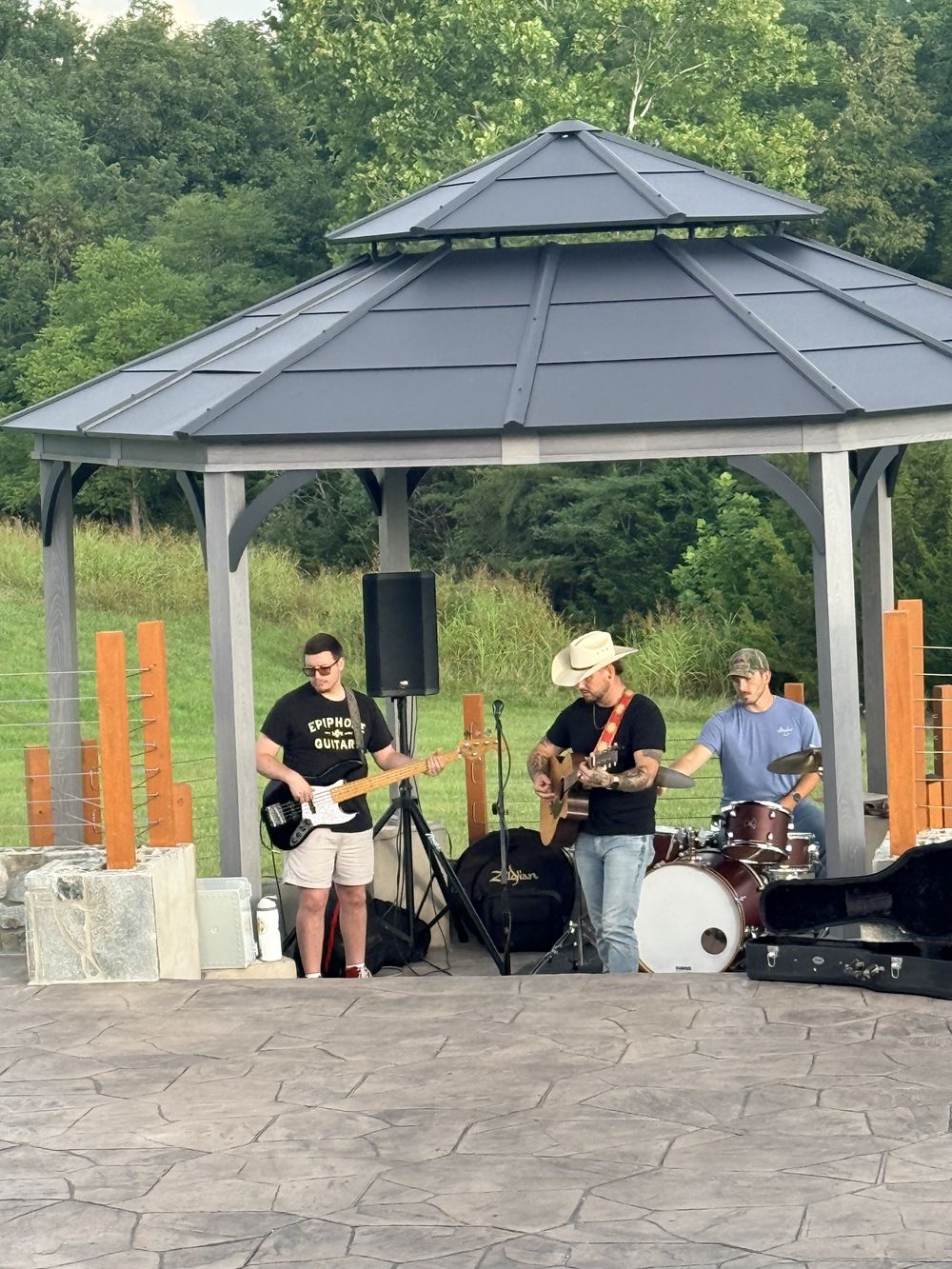 A three-piece band playing under the gazebo