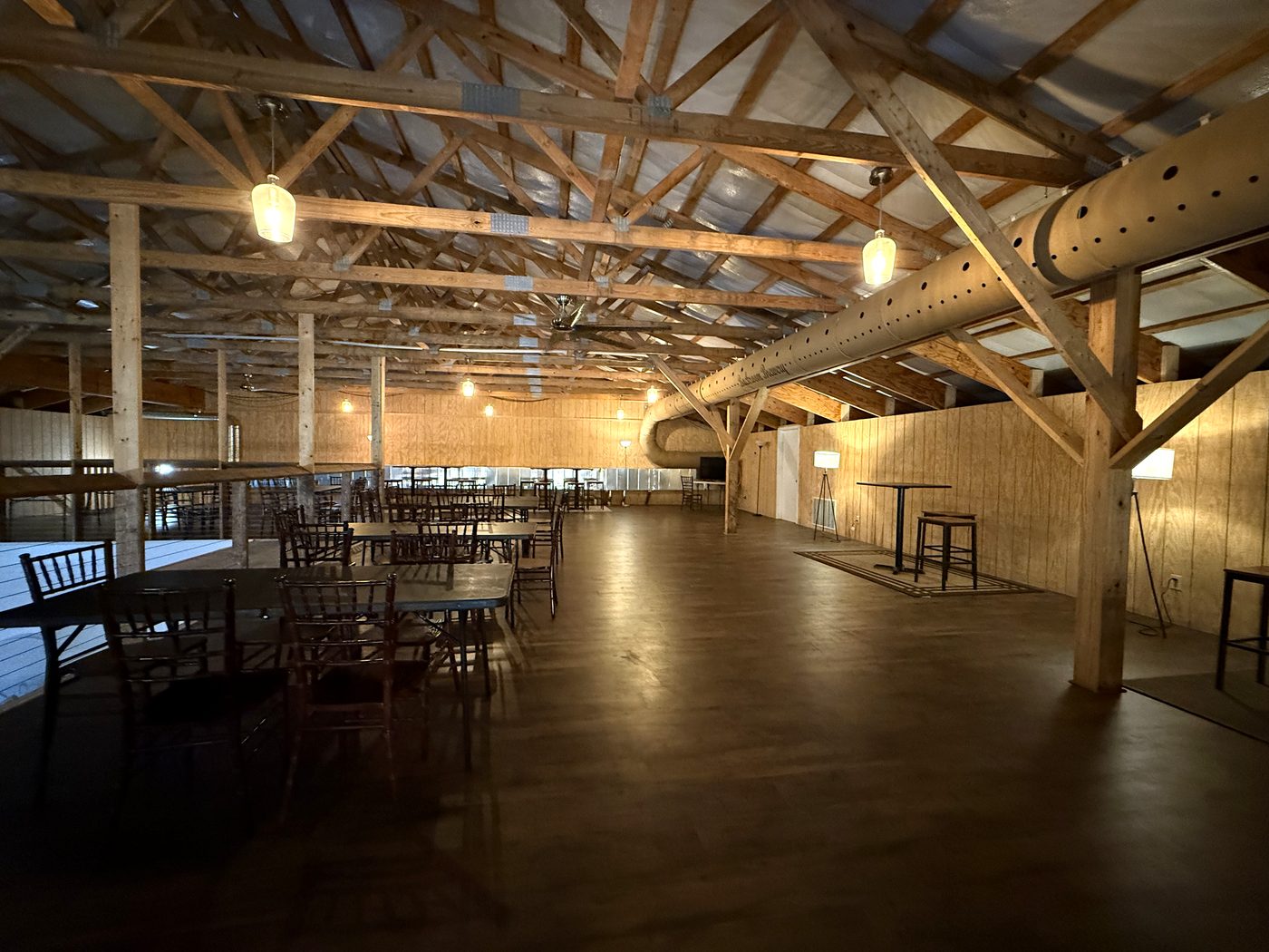 The Mezzanine at Backroom Brewery — timber trusses, pendant lights, and tables set for a party