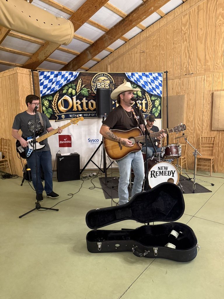The band New Remedy playing inside the Big Barn, the singer in a cowboy hat with an acoustic guitar