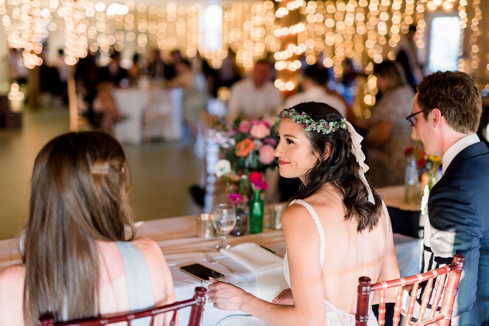 The bride at her table under the string lights